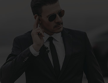 Close-up of a professional bodyguard in a suit using an earpiece to secure a VIP environment.