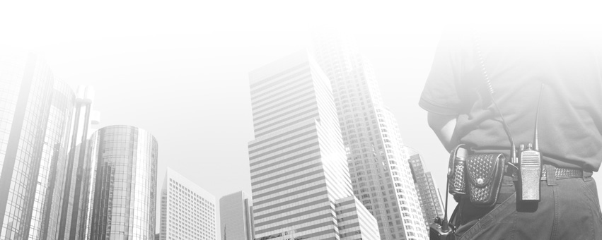 Security guard with radio gear monitoring a high-rise urban area, ensuring building safety and protection.